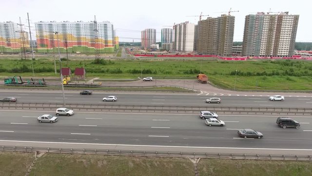 Camera flying along ring road freeway with driving vehicles. Aerial view. St. Petersburg, Russia
