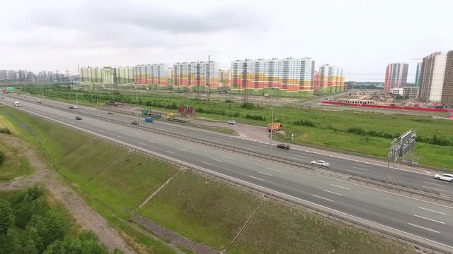 Panorama of ring road freeway with driving vehicles. New dwelling district is at the north. Aerial view. St. Petersburg, Russia
