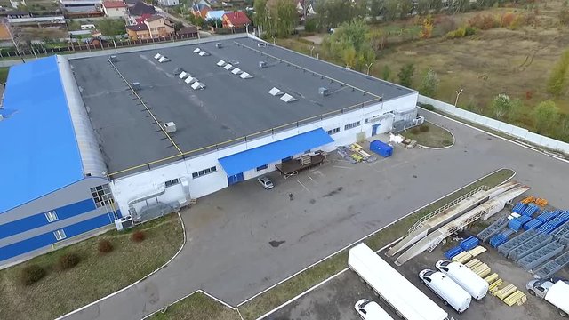 Flight over warehouse storage building exterior HD video. Aerial panorama of industrial area, transport vehicle