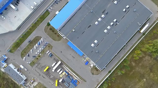 Flight over warehouse storage building exterior HD video. Aerial panorama of industrial area landscape, transport vehicle