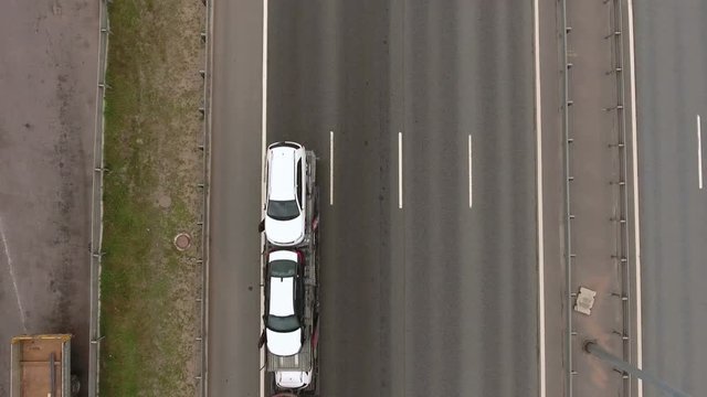 Top view at the lanes of highway with driving cars and trucks. Flying across road

