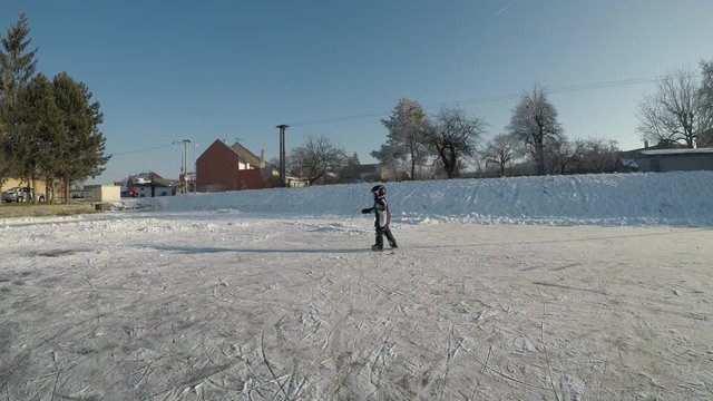 Little boy playing hockey. The child learns to skate and shoot with a stick.
