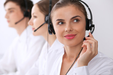 Call center. Focus on beautiful woman in headset