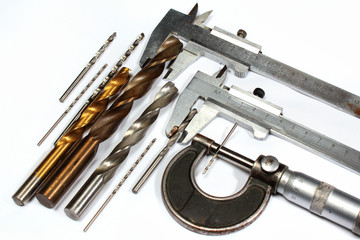 Drill bits and micrometer screw caliper on white background