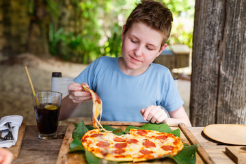 Teenager eating pizza