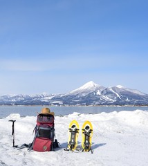 青空と山と雪の湖畔を歩く