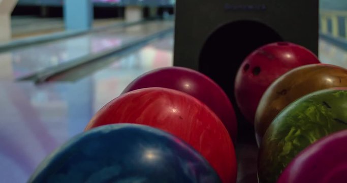 Player hands choose balls for bowling play 4k video. Bowlers select and take balls from ball lift returner. Bowling game leisure equipment