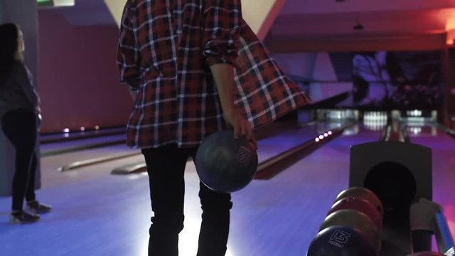 Friends playing and having fun at bowling game HD leisure video. Young man and woman rolling ball throwing to lane. Hobby and competitions