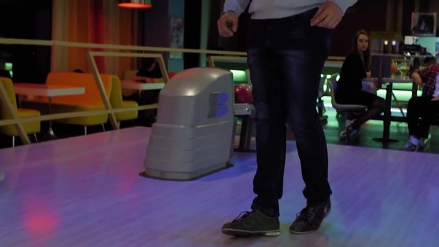 Playing bowling game and player throwing ball to lane HD leisure video. Man rolling ball. Front view from alley wooden floor. Hobby and competitions