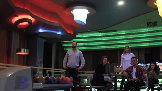 Playing bowling game and player throwing ball to lane HD leisure video. Man rolling ball. Front view from alley. Hobby and competitions