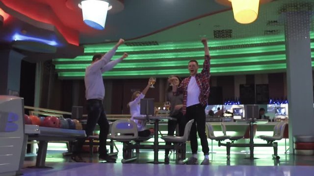 Friends playing and having fun at bowling game HD leisure video. Young man rolling throwing ball. Front view from alley. Hobby and competitions