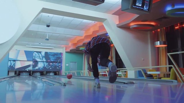 Man chooses bowling ball and rolling to alley HD leisure video. Friends playing hobby game. Guy doing throw