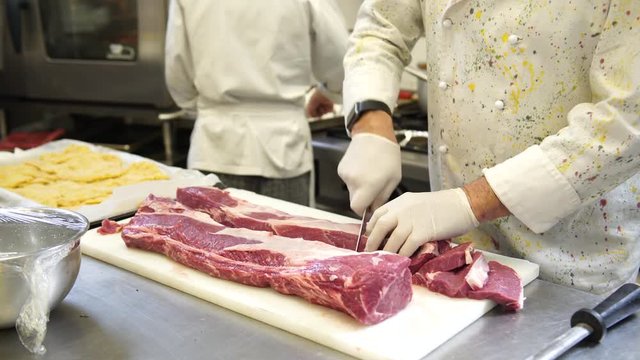 A chef carving the meat for the steaks in his kitchen in Italy, 4K.