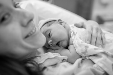 Mother holding newborn baby girl in the hospital