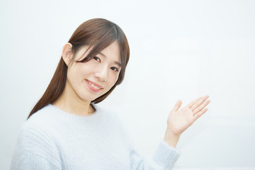 Young woman pointing something with white  background