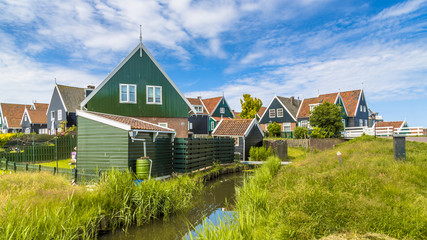 Traditional Dutch fishing village scene with wooden houses and c