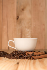 Coffee cup and coffee beans on wood table