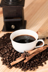 Coffee cup and coffee beans on wood table