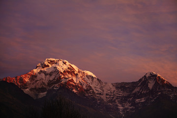 Amazing breathtaking view of sunset over craggy summits of the Himalayan mountain range. Scenery of icy peaks of majestic ancient mountains standing high above valley in the Annapurna Sanctuary