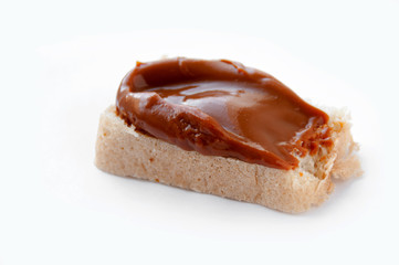 Bread with cooked condensed milk on a white background