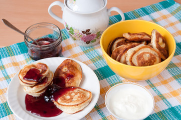 Pancakes for breakfast with cherry jam and sour cream