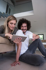 couple relaxing at  home with tablet computers