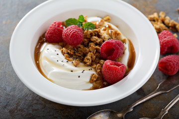 Yogurt bowl with raspberry and maple syrup