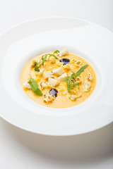 cream soup with popcorn, arugula on white background