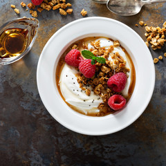 Yogurt bowl with raspberry and maple syrup