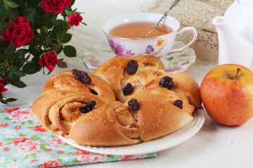 bun roll with apple and cinnamon raisin in a still life on plate bright