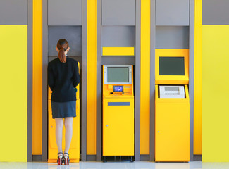 Business young woman inserting a credit card to ATM,  women wear black suit inserting debit card in...