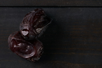 Close up of two dried dates on wooden background