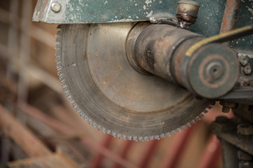 Old rural table circular saw and wooden logs store in the old barn