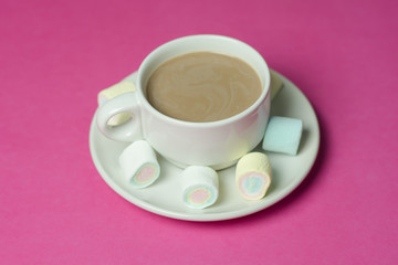 hot chocolate with marshmallows in a ceramic cup on pink paper b