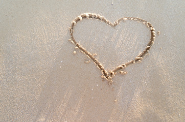 Heart drawn on a sand of beach