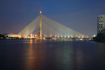 Obraz premium Rama VIII Bridge over the Chao Phraya river in the evening twilight. Bangkok