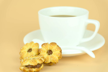 Coffee cup and candy on Orange background.
