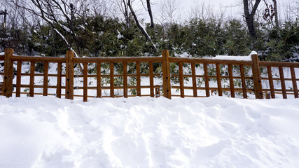 Snow walkway and wooden railing in the forest Noboribetsu onsen