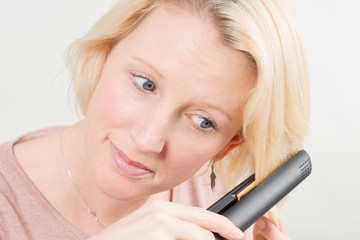 Woman Styling Her Hair with a Straightening Iron