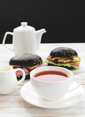 Black Hamburger , cup of tea and milk for breakfast.