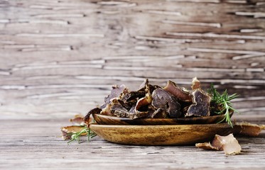 jerked meat, cow, deer, wild beast or biltong in wooden bowls on a rustic table