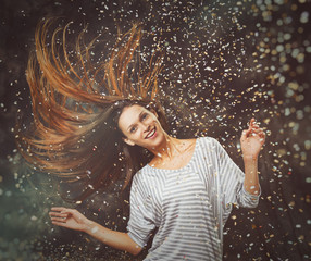 cheerful young woman throwing confetti