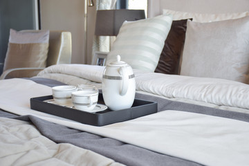 decorative tea cup set on black tray in modern bedroom interior