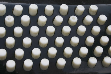 White buttons on a black background. Detail of an accordion