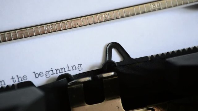 Typing the phrase In the beginning with an old manual typewriter
