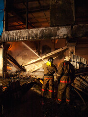 Firemen extinguish a house and building;