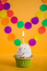 капкейк со свечой на разноцветном фоне