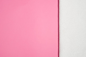 Fototapeta premium White towel on a geometric modern pink paper background top view with copy space
