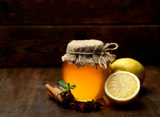 Honey, ginger, lemon and spices on a wooden   background