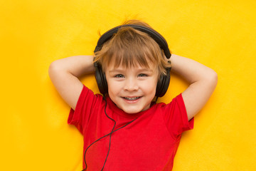 little boy with headphones on yellow background